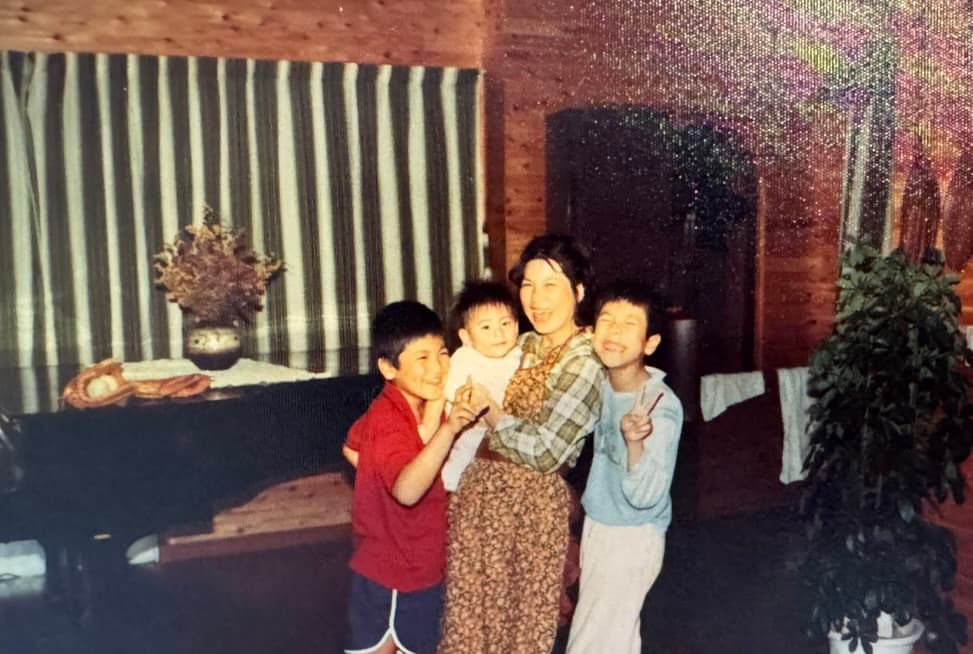 泥のついた手でパインを収穫するしげアンマーと、その横で真剣な眼差しで品質をチェックする息子・翔